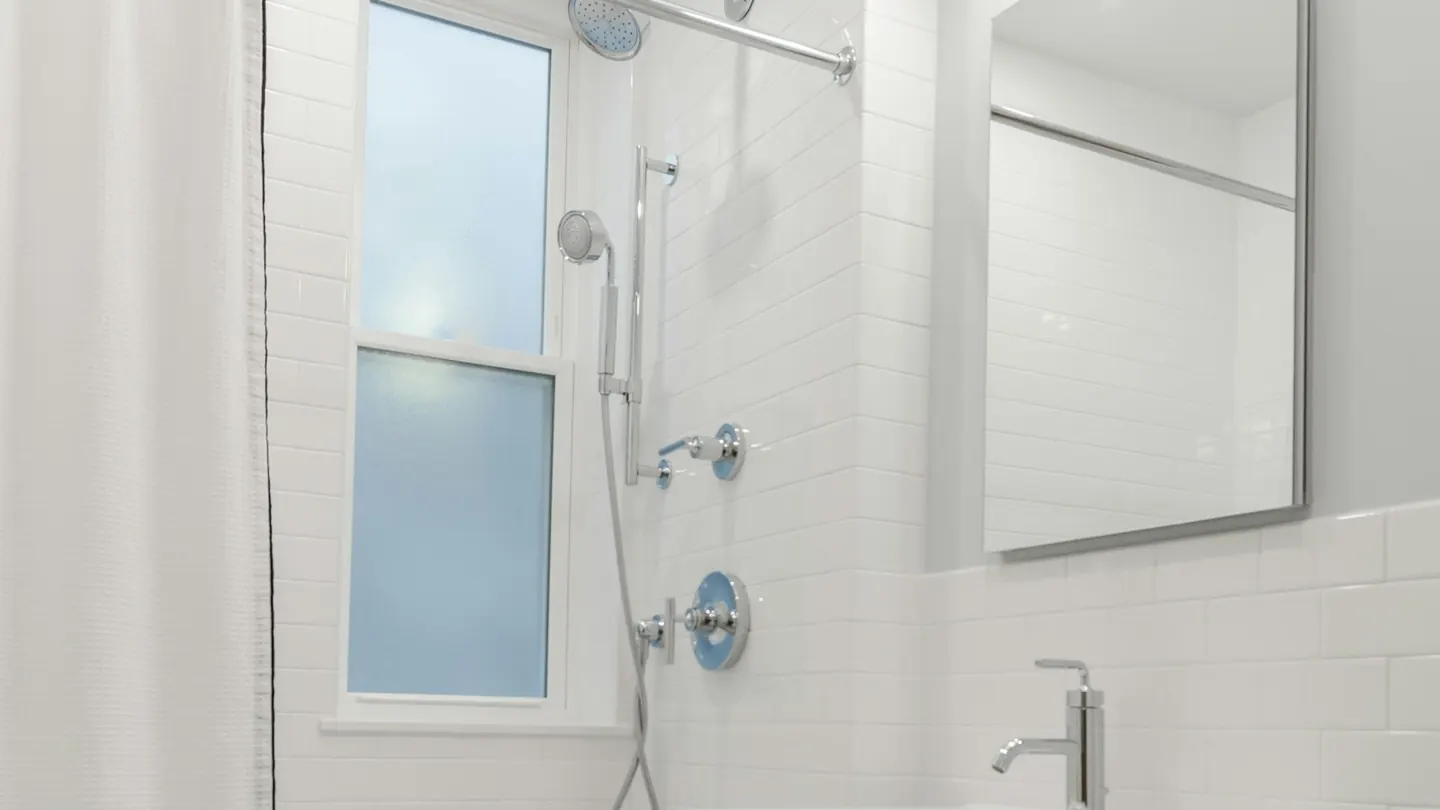 Badkamer met witte wandtegels en spiegel